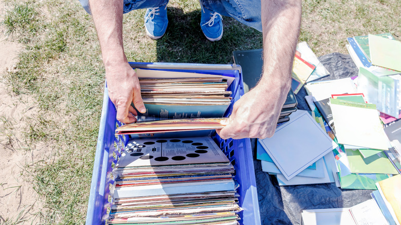 Person flipping through vinyl at a yard sale
