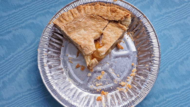 Aluminum pie tin with one slice of apple pie