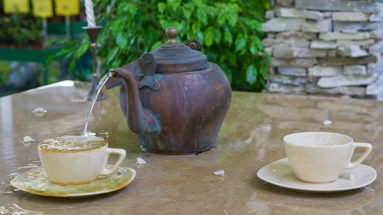 A fountain made with a teapot and teacups