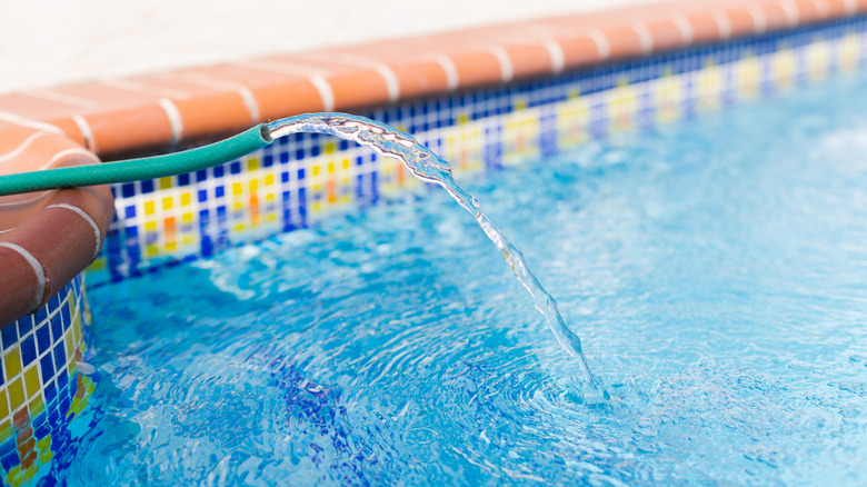 Hose filling up pool with water