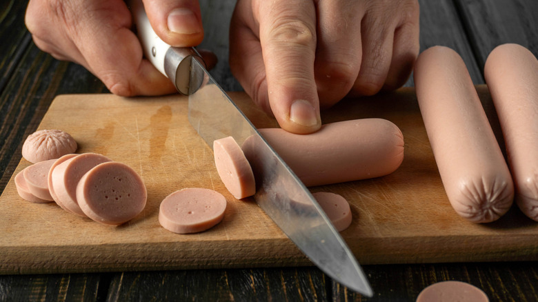 Cutting slices of hot dogs
