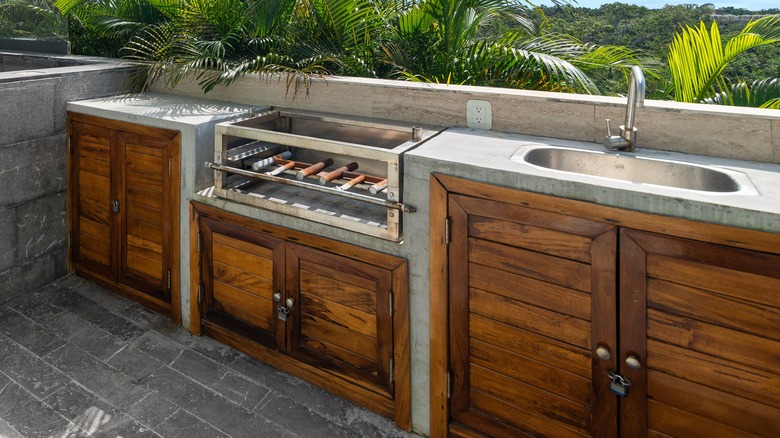 An outdoor kitchen with wooden cabinetry
