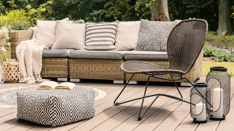 Outdoor rattan furniture, cushions, blankets and a rug