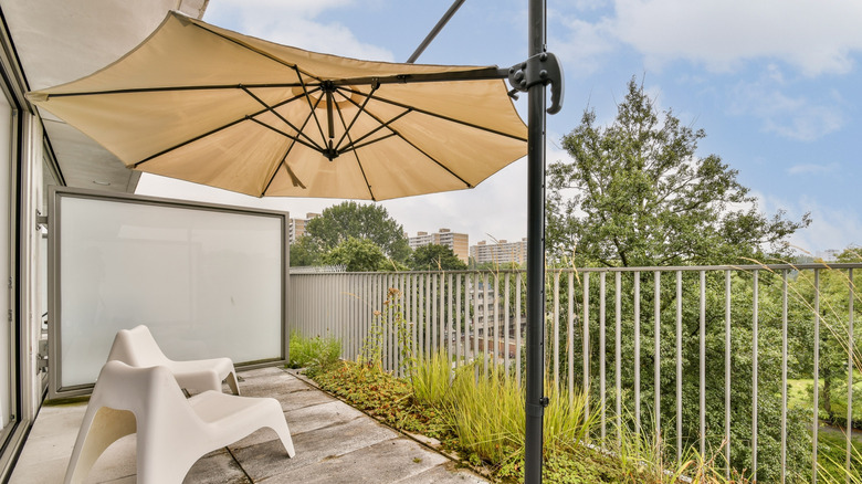 A balcony fitted with a canopy umbrella