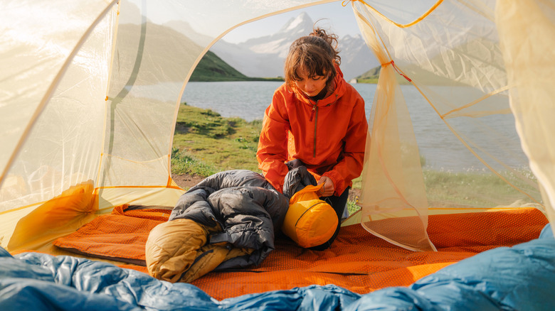 Woman packs sleeping bag into its pouch