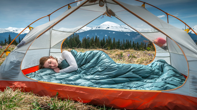 woman sleeping in a tent with no pillow