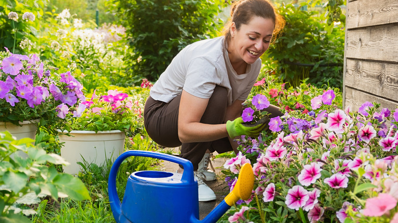 Happy woman caring for flowers