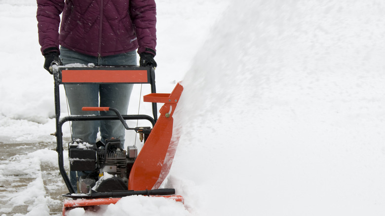 Woman pushing a snow blower