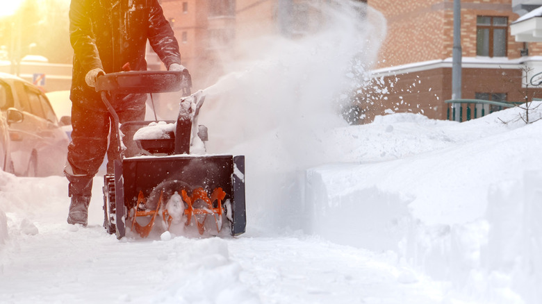 man clears a path with a snowblower
