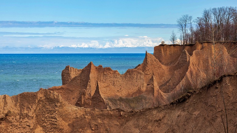 The view from Chimney Bluffs State Park, with jagged sandy bluffs and blue water