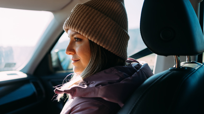 Woman with stocking hat and coat on inside of car