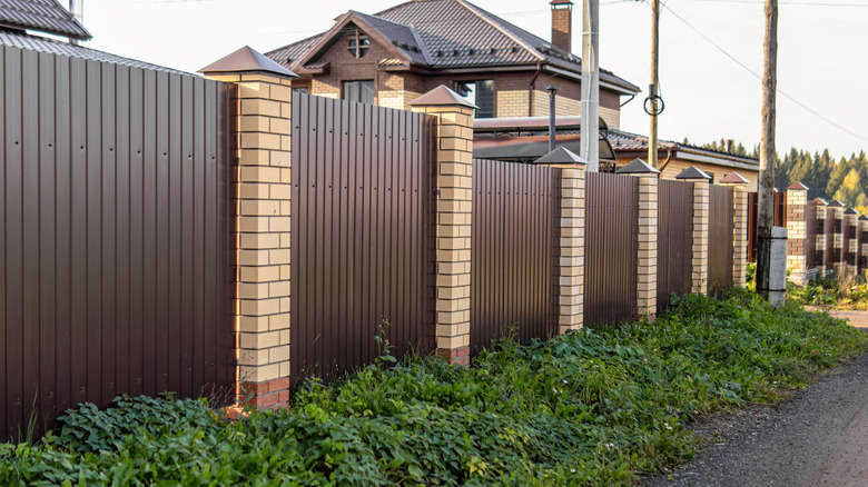A brown fence, built using the stepping method to ensure a clean finish with a slope