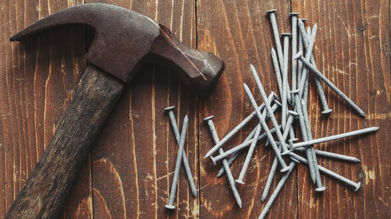 Claw hammer and galvanized nails on wood