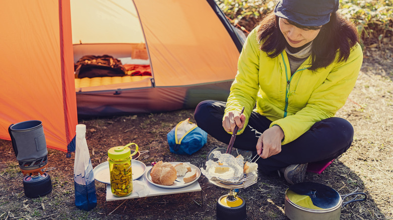 Woman cooking a meal while camping