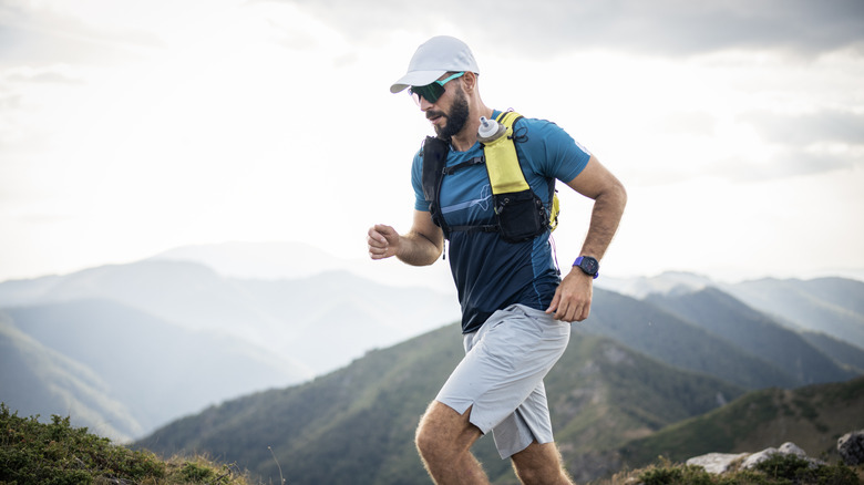 A male trail runner with a mountainous landscape in the background