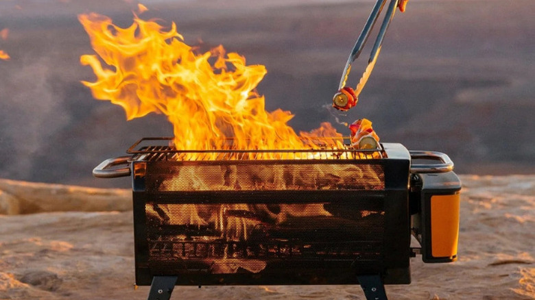 Camper cooking over flames on the BioLite Firepit+