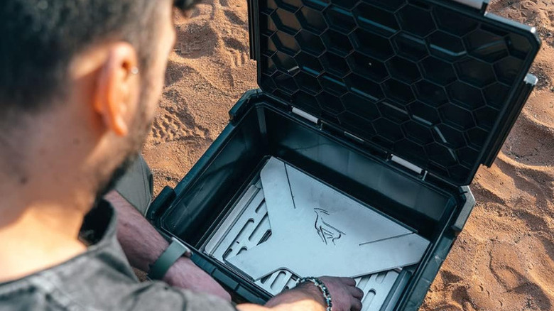 A man unpacking a Front Runner BBQ/Fire Pit