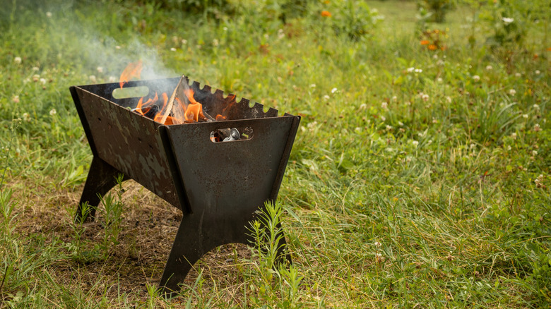 A portable campfire lit in the countryside