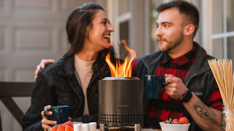 A couple next to their lit Solo Stove Mesa Tabletop Fire Pit