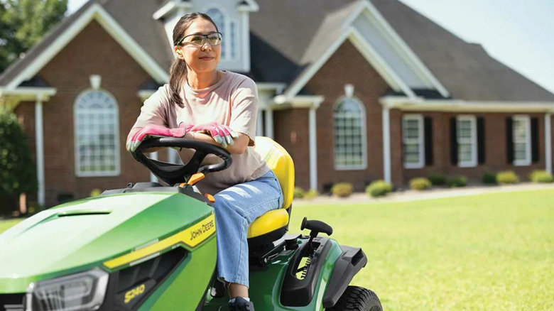 Woman riding a John Deere S240 mower