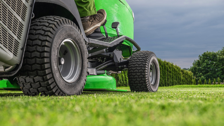A green riding lawn mower seen from below