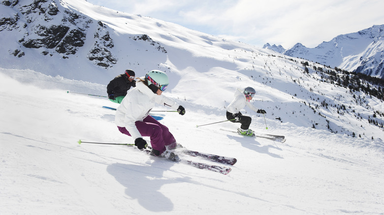 Three skiers going down a mountain