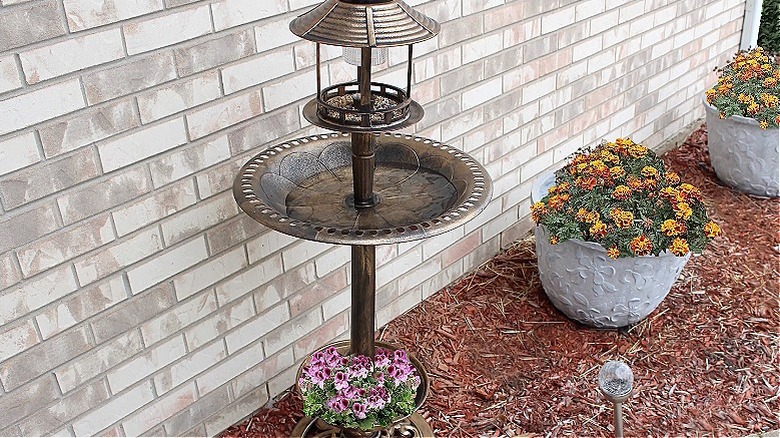 birdbath with planters on the bottom and seed above the bath