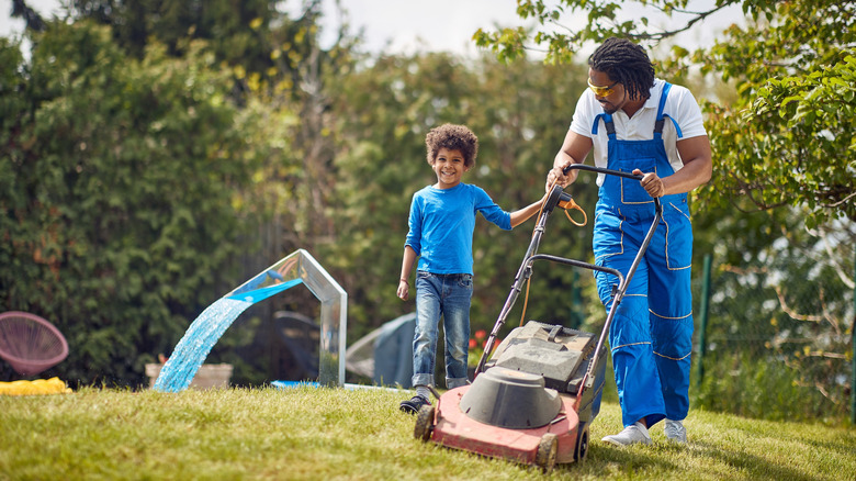 Man mows lawn as child tries to participate