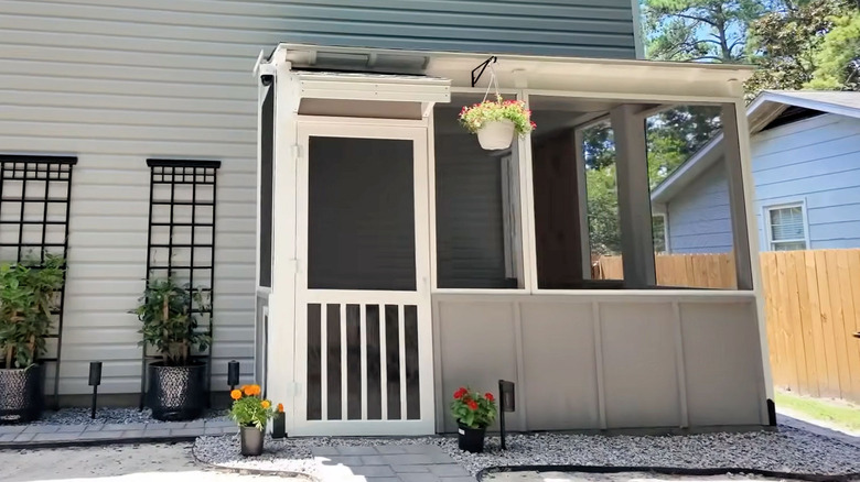 A DIY screened-in porch on the back of a house.