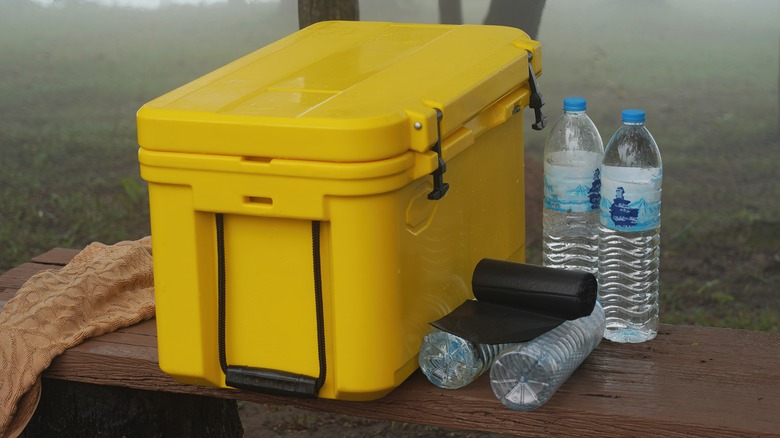 Yellow cooler box and water bottles on bench