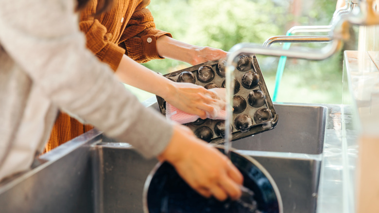 Two people washing dishes in campground sink