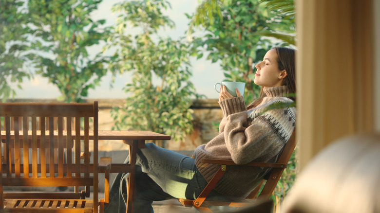 Woman on terrace outside of home, relaxing