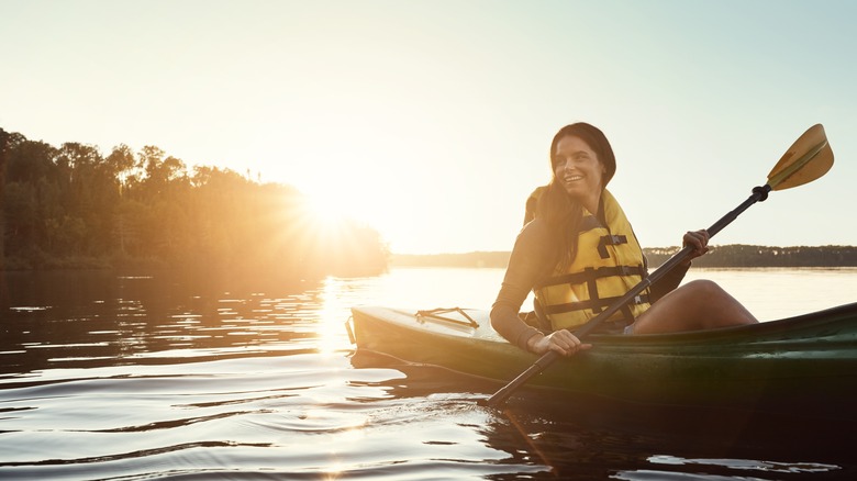 Woman kayaking at sunset