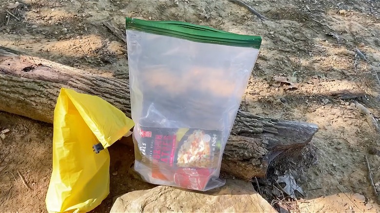 OPSAK Odor Proof bag resting on log outside