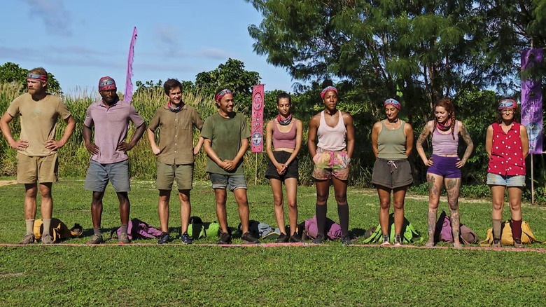 Survivor contestants standing in row outside