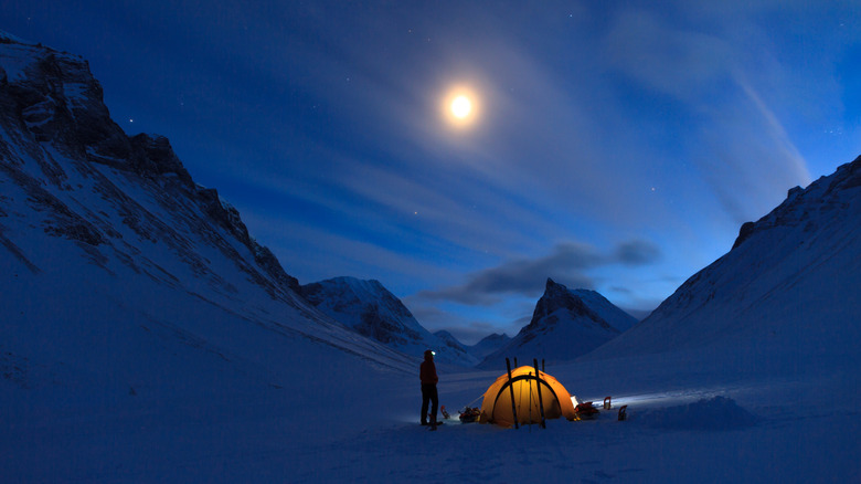 Person looks at sky while camping in a snowy place