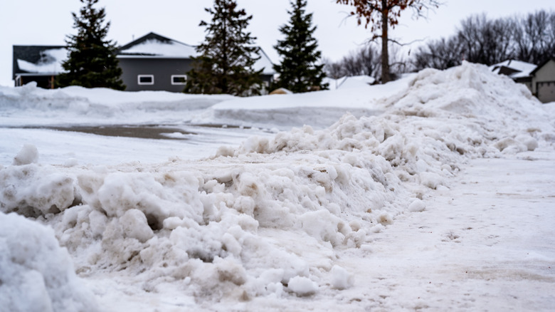 Piles of snow left by snowplow at end of a driveway