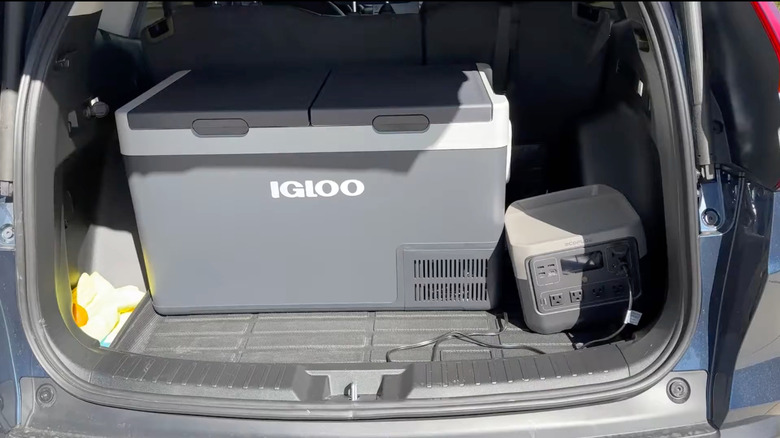 An Igloo Dual Zone Active Cooler in a vehicle cargo area, connected to an EcoFlow portable power station