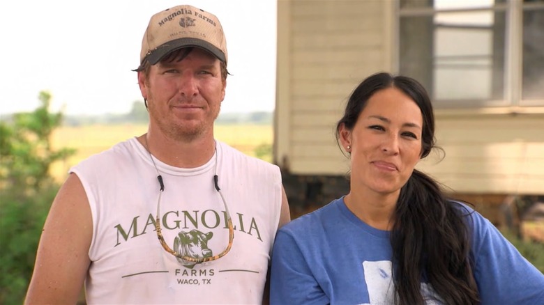 Chip and Joanna Gaines smiling outside of a house
