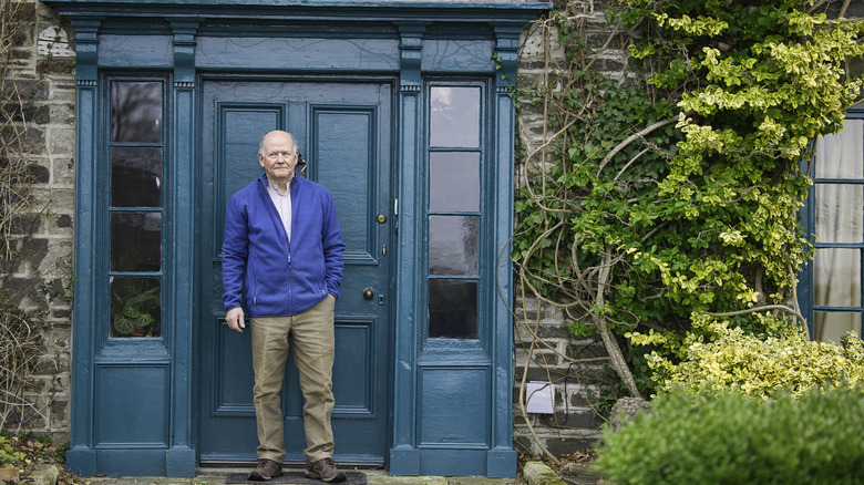 Man stands in front of teal front door