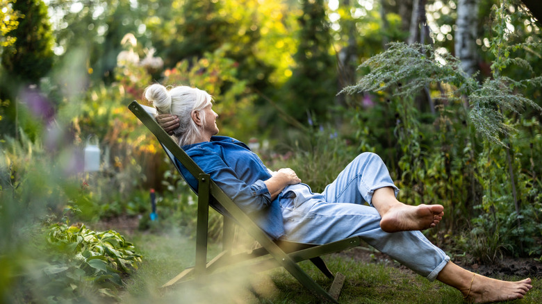 woman relaxing in private plant-filled yard