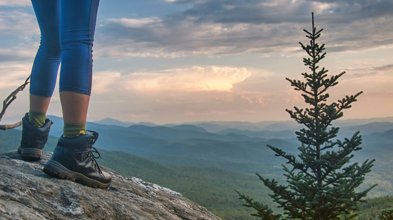 Hiker standing on Mount Mansfield overlooking valley