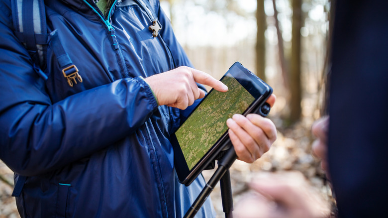 Man using tablet to plan hiking route