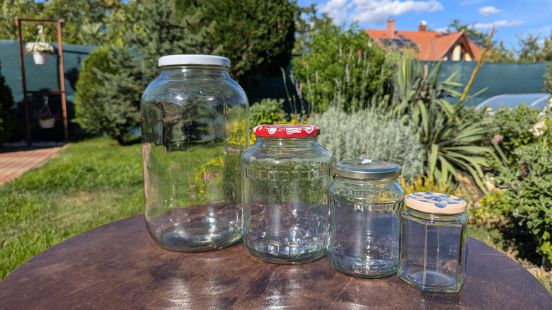 Empty glass jars on a table in a backyard garden