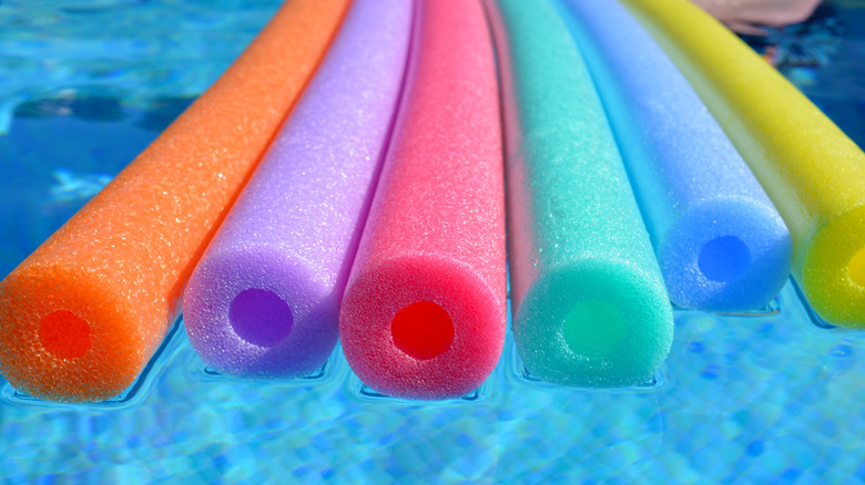 Colorful pool noodles in pool 