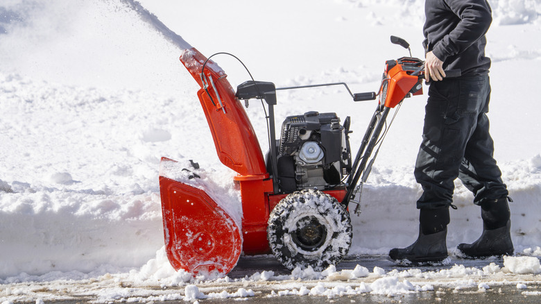 Person using snow blower to remove snow