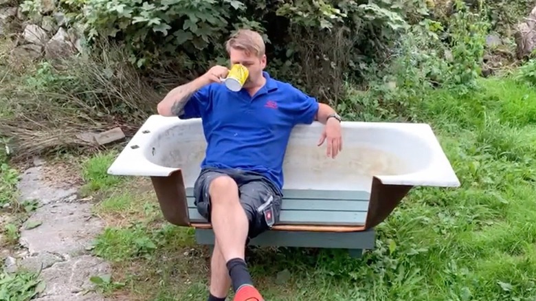 A DIYer sits in his freshly-made bathtub seat