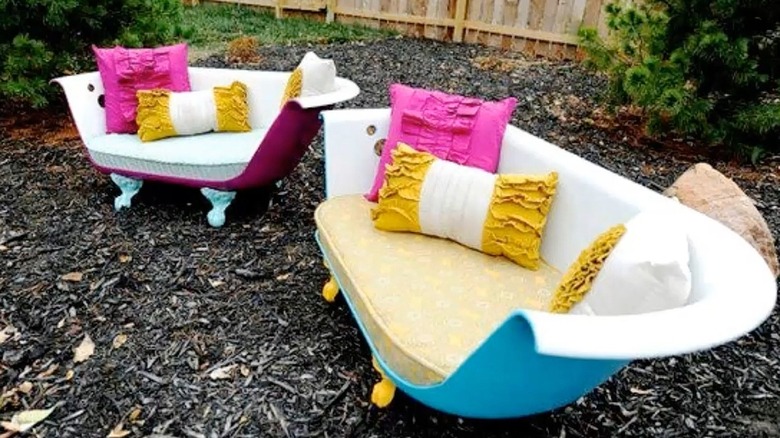 A pair of bathtub benches in a mulched garden setting