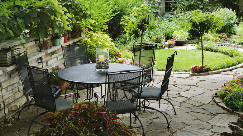 A round table and chairs on a beautifully-landscaped patio