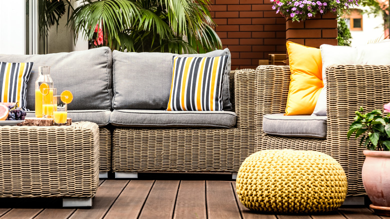 A cozy seating area with plants and naturally-colored rattan furniture